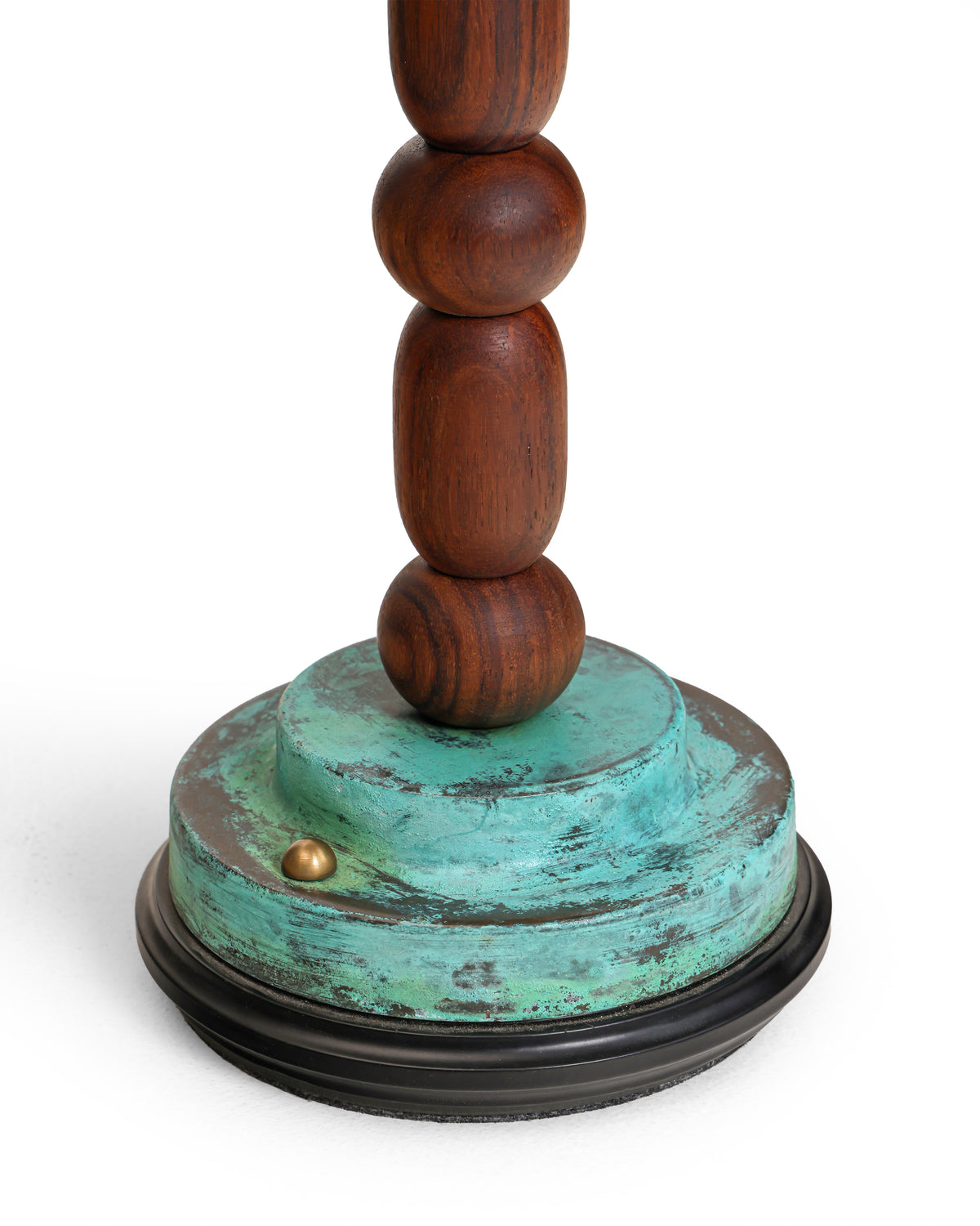 Brass touch switch on the stepped verdigris base of Totem II lamp