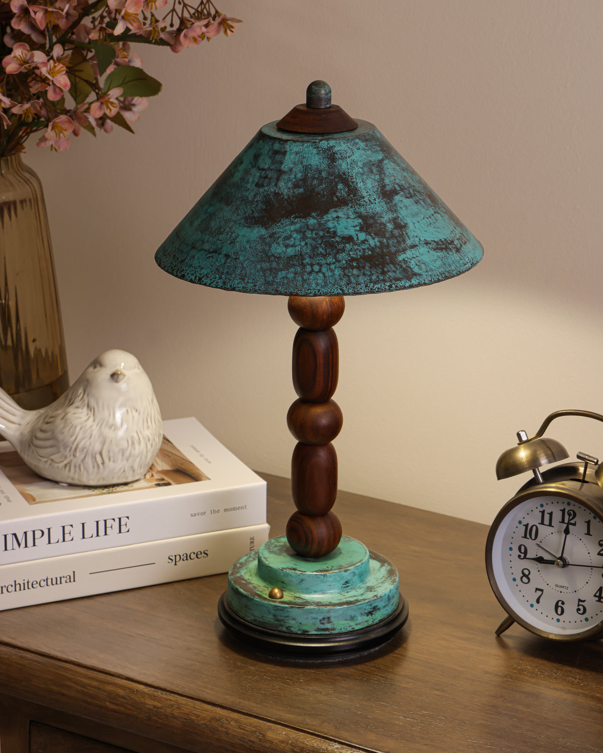 Totem II cordless lamp glowing warm on a console beside books and a clock
