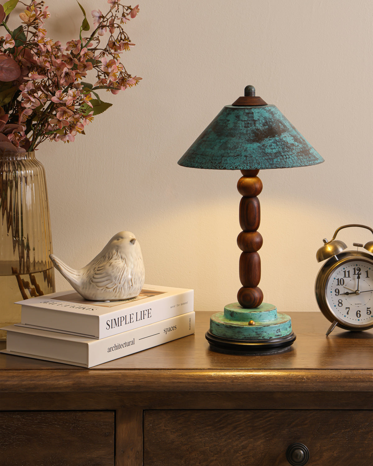 Totem II rosewood table lamp with verdigris brass shade, styled on a wooden console